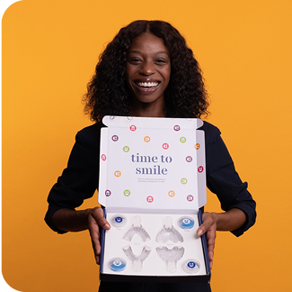Woman holding a product packaging with 'time to smile' text on an orange background