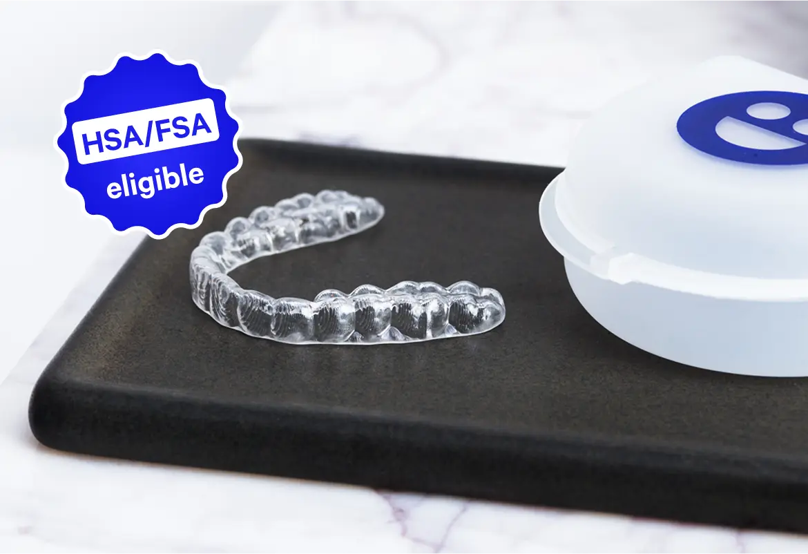 Clear dental aligner on a black tray with a white container, HSA/FSA eligible label.