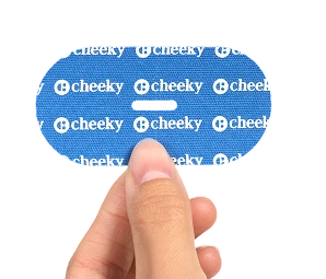 Hand holding a blue 'cheeky' product packaging against a white background